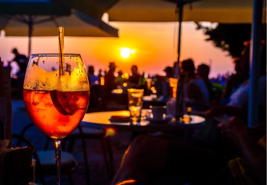 Tramonto estivo, bevanda fresca, atmosfera rilassata e gioiosa in un bar all'aperto.