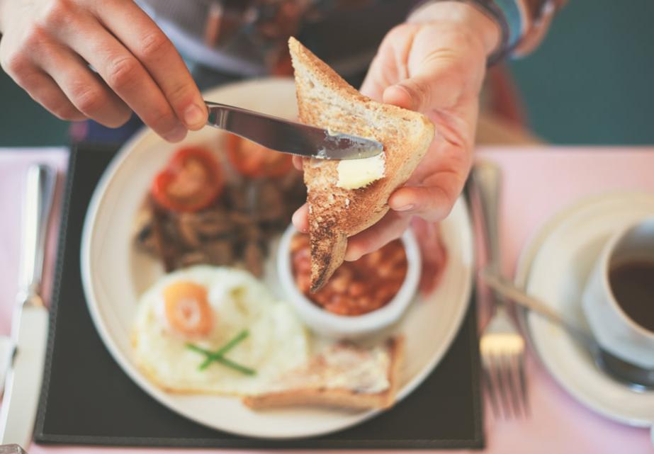 Colazione accogliente con toast, uova, fagioli e caffè caldo.