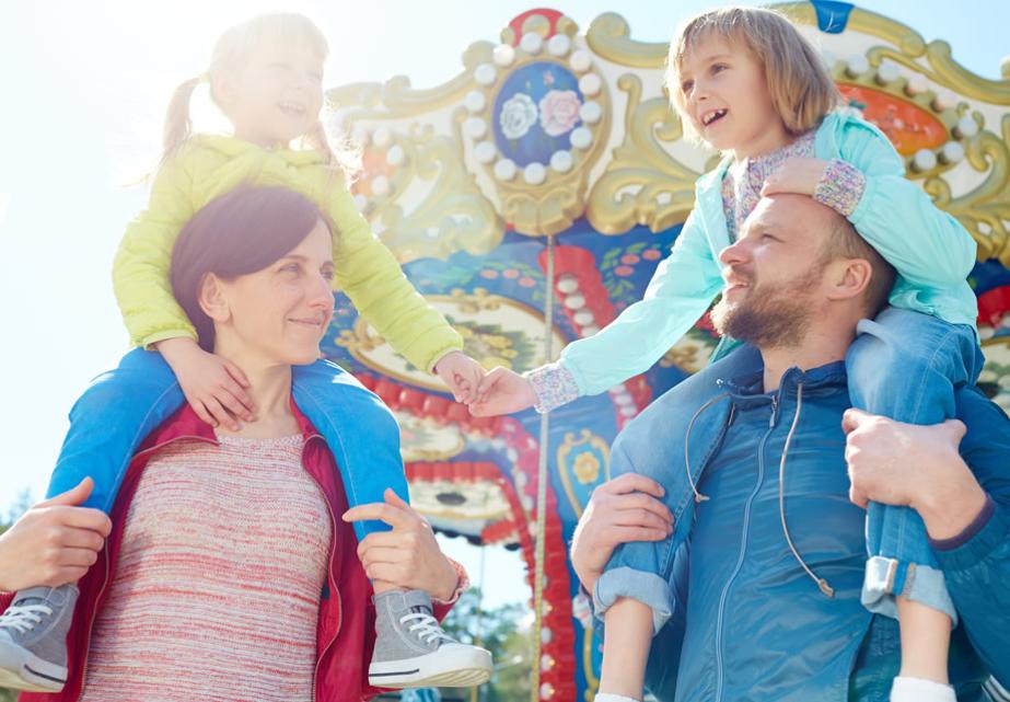 Famiglia felice al luna park, sorrisi e gioia sotto il sole.