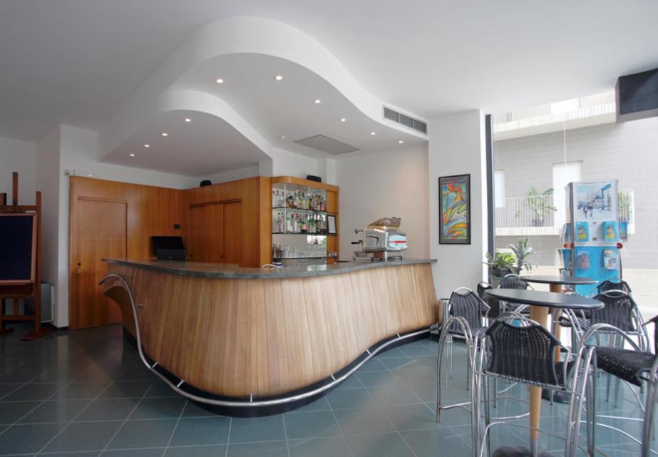 Moderno bar con bancone curvo, atmosfera luminosa e accogliente.